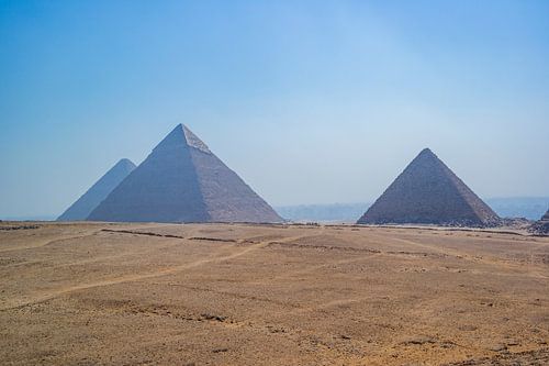Piramides van Gizeh met blauwe lucht en woestijn op de voorgrond