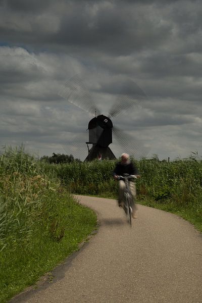 Fietser bij molen met draaiende wieken by Renske Breur