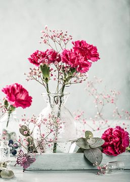 Roze anjers bloemen in de glazen vaas