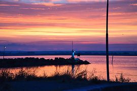 Lighthouse in the harbour at sunset by Martin Köbsch