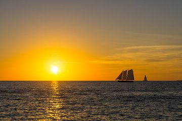 USA, Florida, Intense orange sunset sky over two silent sailing ships by adventure-photos