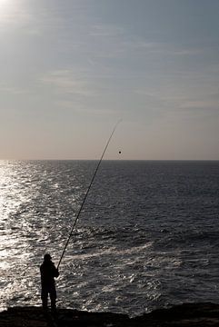 Visser aan zee bij ondergaande zon van Margot van den Berg