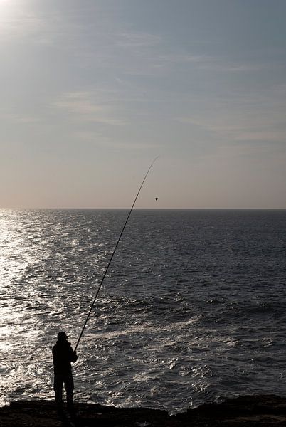 Fisherman by the sea at sunset by Margot van den Berg