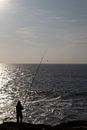 Visser aan zee bij ondergaande zon van Margot van den Berg thumbnail