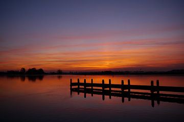 Zonsondergang / A dock at a river when the sun comes up. van G. de Wit