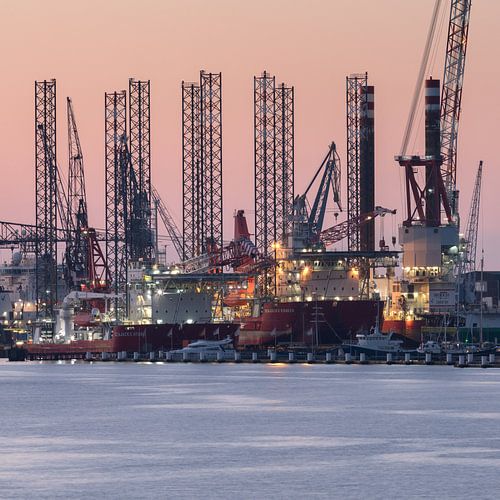 Boorplatform met lichtjes aan het IJ in Amsterdam bij ondergaande zon