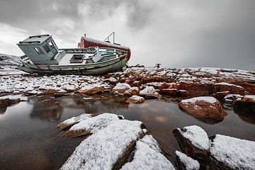 Scheepswrak in de sneeuw op rotsen in Groenland van Martijn Smeets