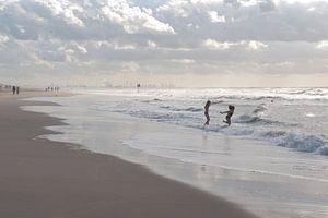 Twee meisjes rennen de zee in bij Scheveningen van Remke Spijkers