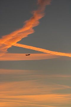 Zonsondergang met een bewolkte lucht en een vliegtuig van Maarten Borsje