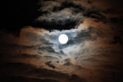 Maan verlicht kleurrijk de wolken