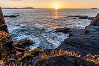 Côte rocheuse sombre de l'Angleterre, eau de mer rugueuse, coucher de soleil