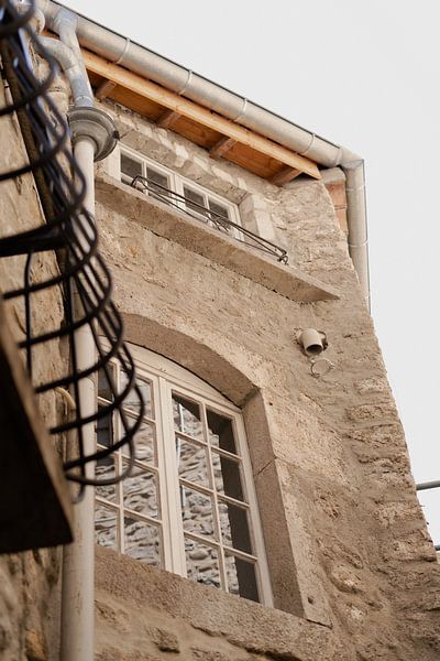 beige house in France with white frames and a black balcony. by Fotograaf Elise