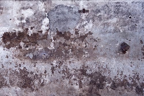 Verweerde betonnen wand in  grijs blauw en bruintinten