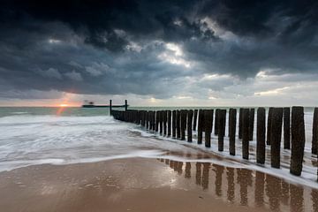 Dutch clouds and typical breakwater of wooden poles along the coast of Zeeland by gaps photography