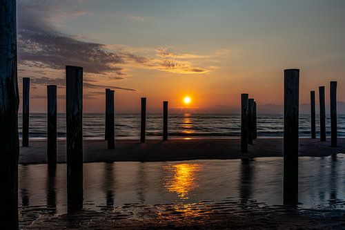 Het Palendorp in Petten vlak voordat de zon ondergaat in de Noordzee.