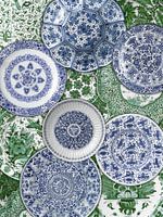 Collection of Delft blue plates on green background, Rijksmuseum