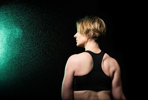 Low key studio portrait of a 35 year old white woman turning her