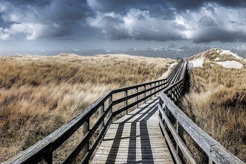 Houten plankenpad door de duinen van Sylt naar het strand