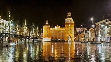 Das schön beleuchtete Rathaus von Goes spiegelt sich in den nassen Klinkern des Platzes von Gert van Santen
