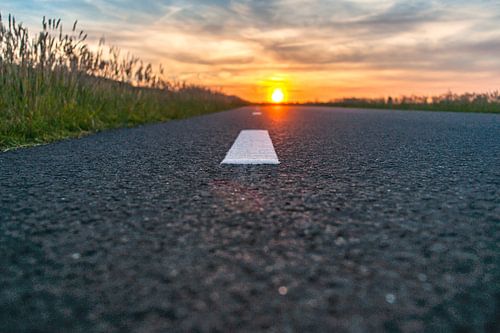 Open asphalt road towards the setting sun