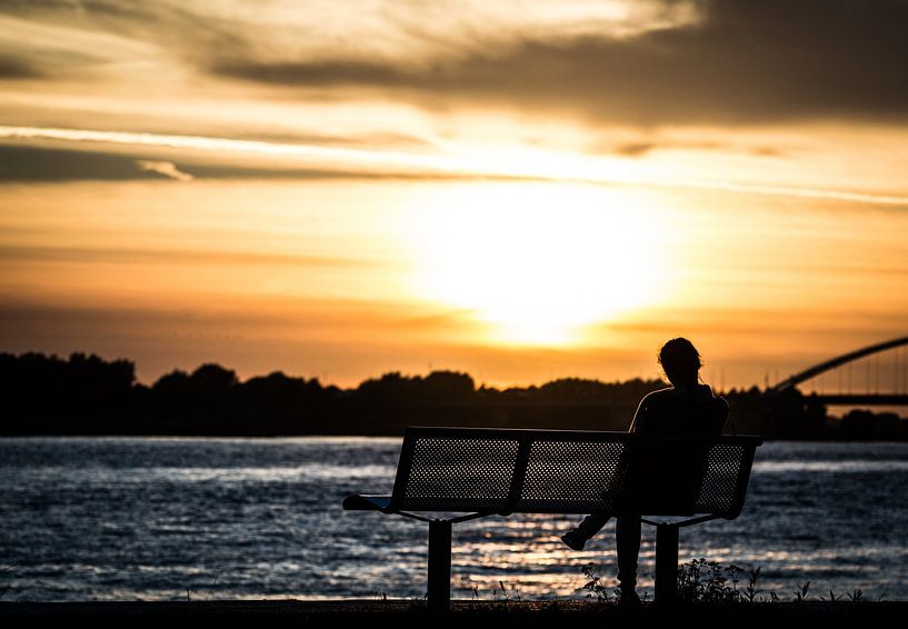 zitten bij zonsondergang van Rick Koppelaar