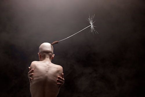 Ingetogen Schoonheid: Kalende Vrouw met Paardenbloemzaadje op Achterhoofd