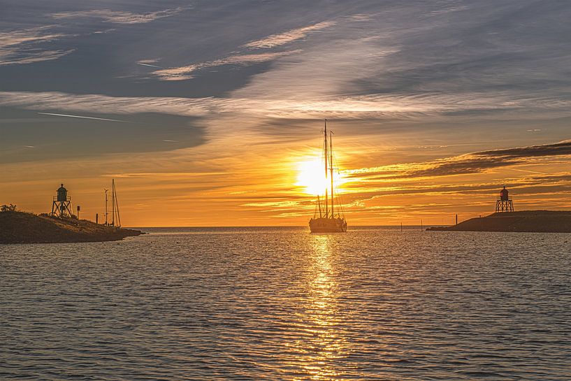 Sunset over the harbor entrance of Stavoren, Friesland. by Harrie Muis