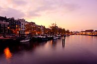 Stadsgezicht van Amsterdam aan de Amstel in Nederland bij avond van Eye on You thumbnail