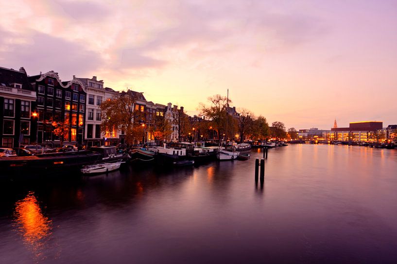 Stadsgezicht van Amsterdam aan de Amstel in Nederland bij avond par Eye on You