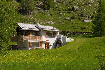 Typical Swiss mountain house with water wheel
