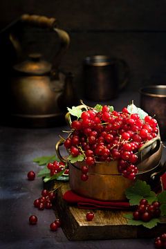 Red berries in copper pans by Saskia Schepers