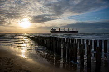Le soleil couchant avec une bateau sur la plage Zoutelande Zeeland