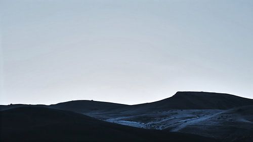 Silhouet van een donkere bergketen in de schemering