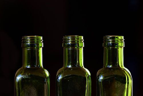 three empty green glass bottles