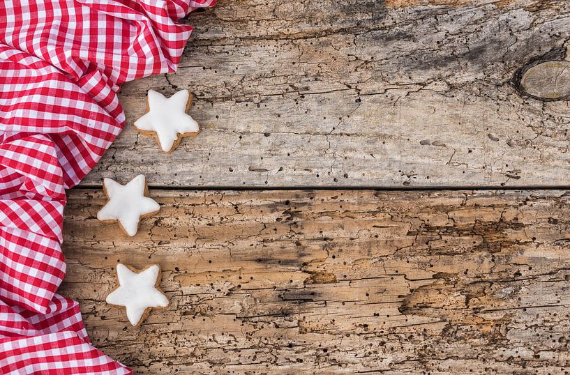 Kekse in Form eines Weihnachtssterns auf einer rot-karierten Stoffborte von Alex Winter