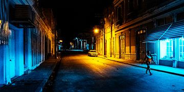 Wandelaar loopt in een donkere straat in Cuba verlicht door een lantaarn van MICHEL WETTSTEIN