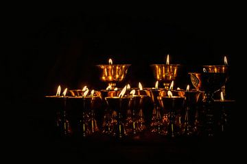 Burning butter candles in a dark temple in Tibet by Rietje Bulthuis