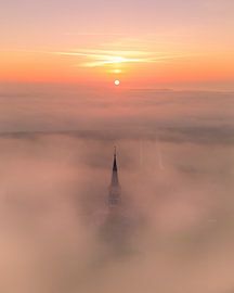 Church tower above fog at sunrise by Ewold Kooistra