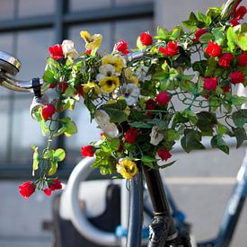 Guidon d'un vélo joyeusement décoré de fleurs sur Henk Vrieselaar