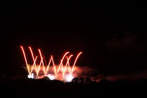 Rode vuurwerkraketten vliegen door de lucht met intense heldere
