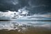 Stormachtige luchten met reflecties op het zand van Remco Piet