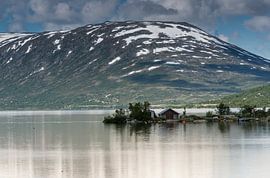 old house at a fjord with mountains with snow in the summer as background by ChrisWillemsen