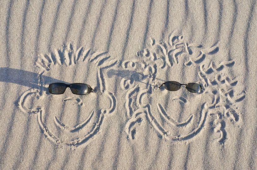faces drawn in the sand on the beach of the Baltic Sea by Martin Köbsch