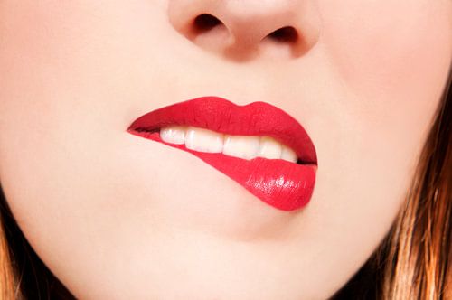 Junge Frau beißt sich auf die Unterlippe