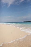 Strand und Meer mit Wolken und einer Insel