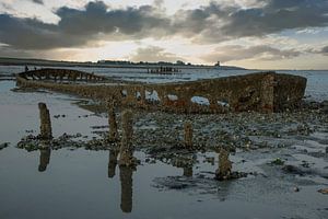 Sonnenuntergang am Wattenmeer mit einem Schiffswrack
