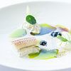 Plat de poisson à la vinaigrette verte sur assiette blanche sur John Stijnman