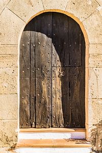 Gros plan d'une vieille porte d'entrée en bois entrée de résidence avec arc en pierre sur Alex Winter
