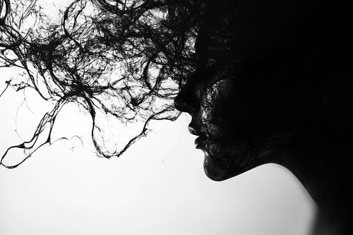 silhouette van jonge vrouw met wapperend haar in zwart wit