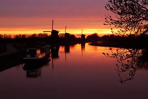 Drie molens bij zonsondergang